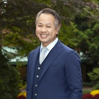 Loc Truong stands outdoors in a blue suit